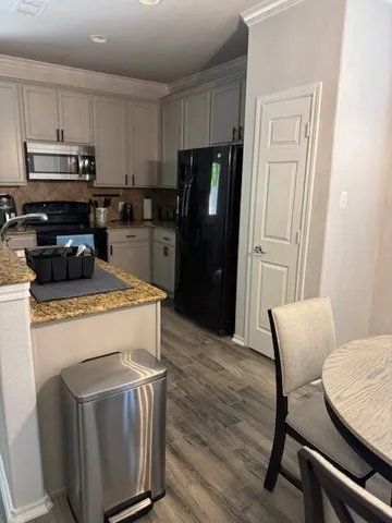 a kitchen with a table chairs refrigerator and microwave
