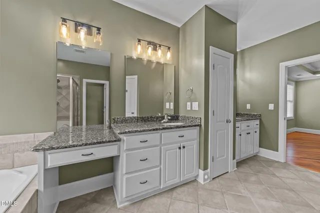 a bathroom with a bathtub a shower and a sink