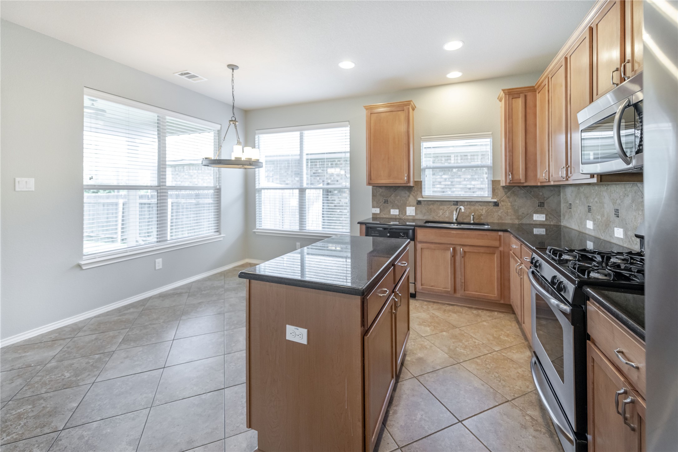 11221 Old Quarry Road Austin, TX 78717 - Photo 3 of 19 Gleaming stone countertops and warm wood cabinetry anchor this functional open kitchen space.