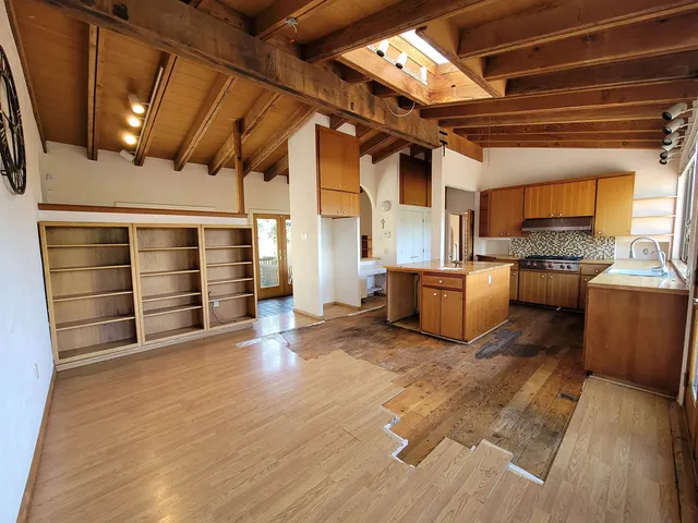 a large kitchen with wooden floors and stainless steel appliances