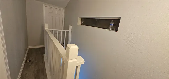 a view of a livingroom with wooden floor and staircase