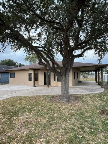 a tree in front of a white house