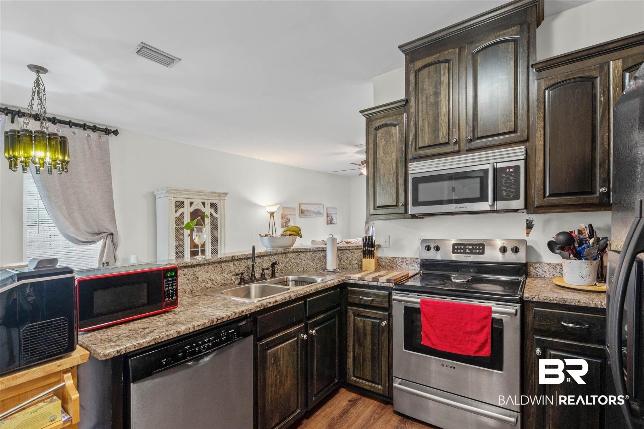 800 Galoway Avenue Mobile, AL 36609 - Photo 6 of 22 Kitchen featuring dark wood-finish cabinetry, light-toned countertops, a stainless steel range, and an undermount double sink