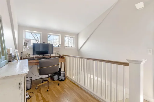 a view of a workspace with furniture and a window