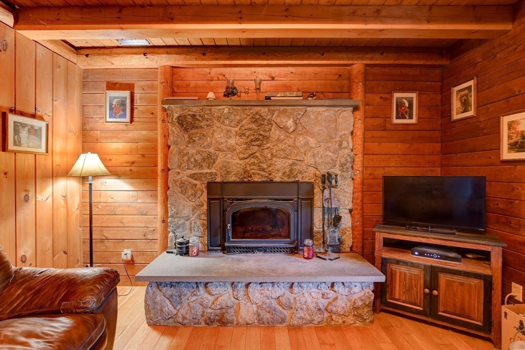 23 Dana Road Petersham, MA 01366 - Photo 8 of 32 a living room with a fireplace and a flat screen tv