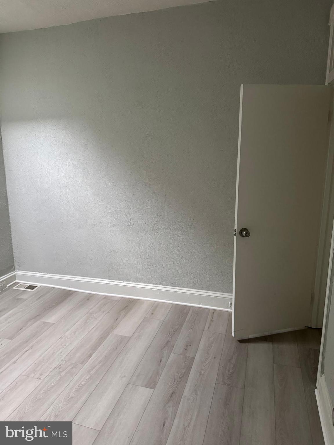 2240 Cedley Street Baltimore, MD 21230 - Photo 5 of 12 an empty room with wooden floor and window