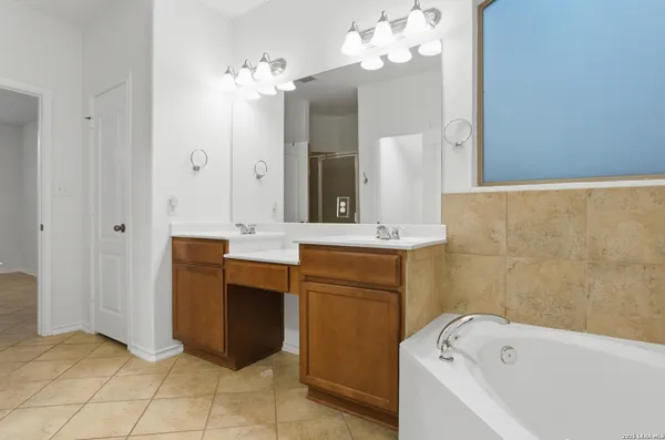 a bathroom with a bathtub sink and a mirror