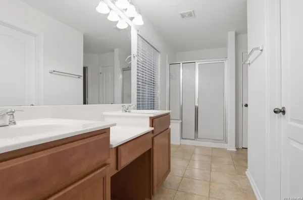 a bathroom with a sink a vanity a mirror and a shower