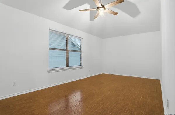 an empty room with a window and a fan