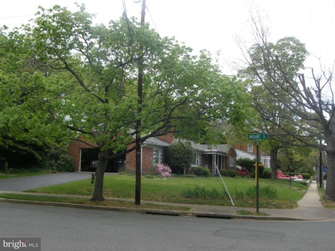 3306 Russell Road Alexandria, VA 22305 - Photo 20 of 21 a yellow house with a yard and large trees