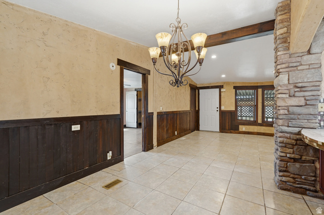 2875 North Hill Field Road, Unit 111 Layton, UT 84041 - Photo 8 of 30 Unfurnished dining area featuring a wainscoted wall, a chandelier, and light tile patterned floors