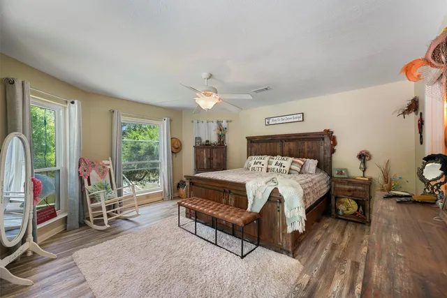 a bed sitting in a spacious bedroom next to a window