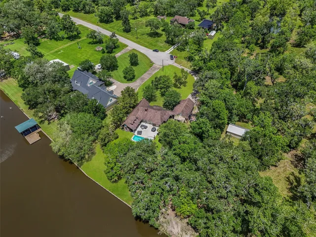 an aerial view of residential house with outdoor space and trees all around