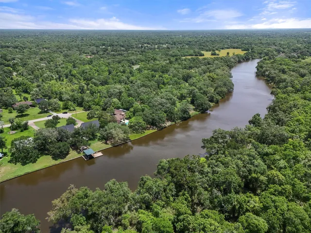an aerial view of city and lake with trees all around