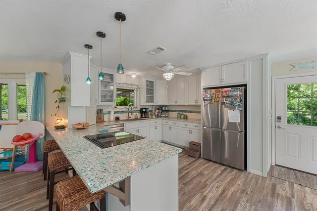 a kitchen with refrigerator and wooden floor