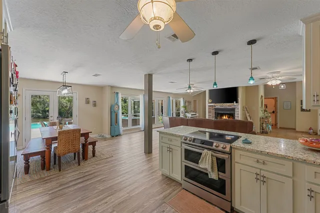 a large kitchen with stainless steel appliances granite countertop a stove and a wooden floors