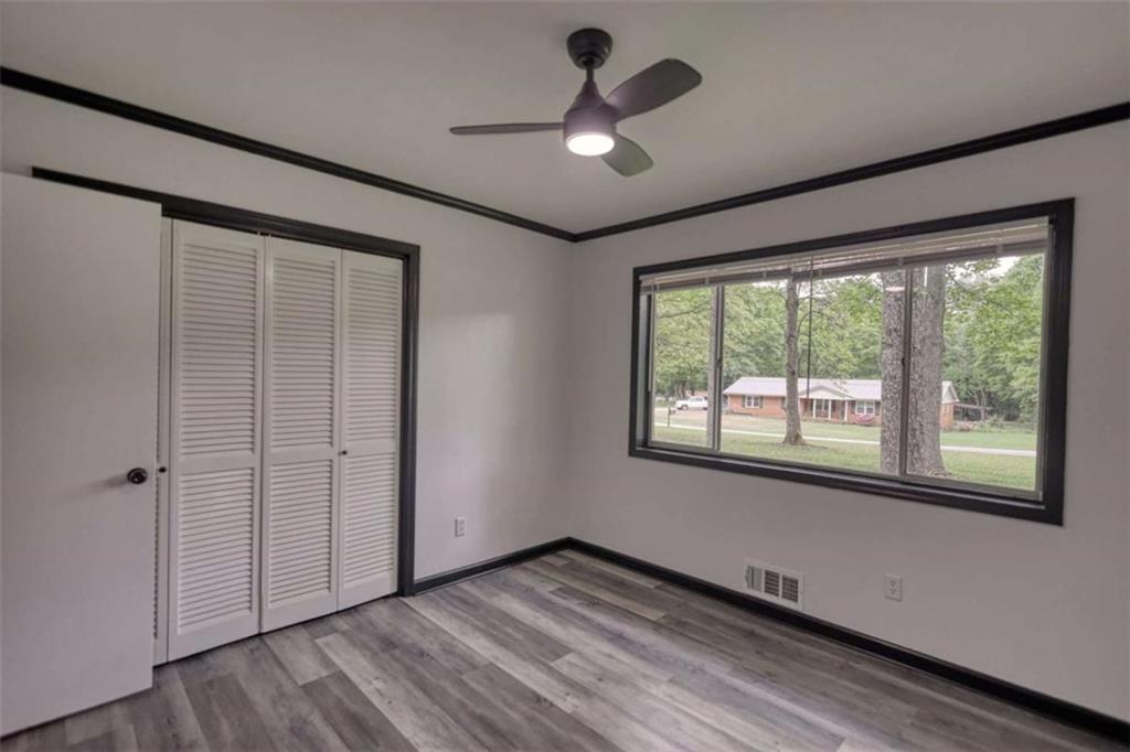 555 Joy Street Jackson, GA 30233 - Photo 30 of 56 a view of an empty room with a window and wooden floor