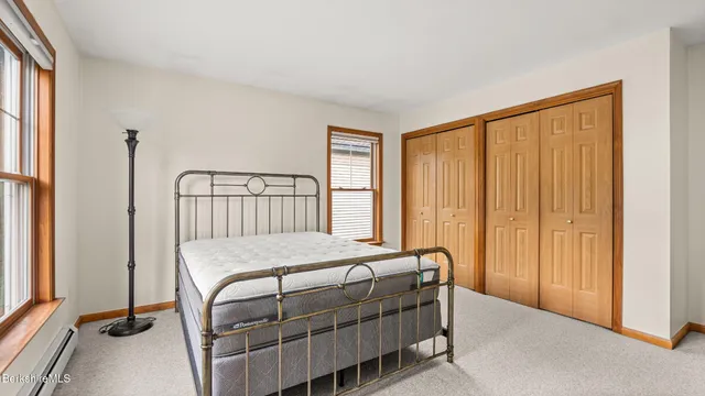 a bedroom with a bed a window and walk in closet