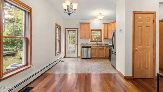 a view of a kitchen with a stove wooden floor cabinets and a kitchen
