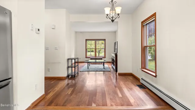a view of a hallway with wooden floor and windows