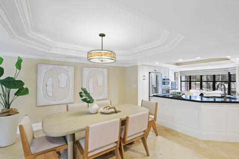 a kitchen with stainless steel appliances kitchen island granite countertop a table and chairs in it