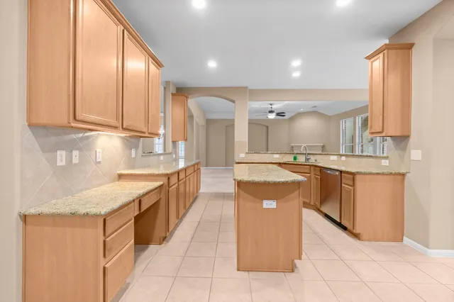 a large kitchen with stainless steel appliances granite countertop a stove a sink and a refrigerator