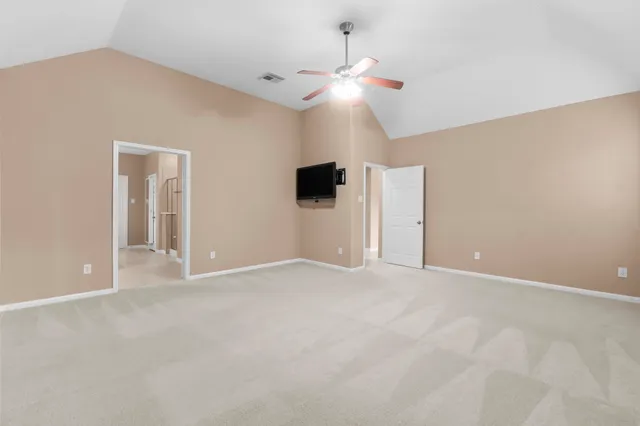 a view of an empty room with a chandelier fan