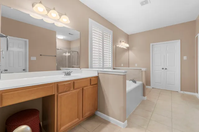 a spacious bathroom with a double vanity sink mirror and bathtub