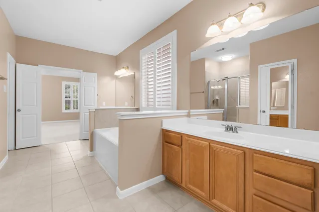 a bathroom with a sink a vanity a mirror and a bathtub