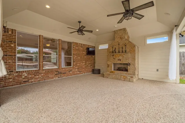 a view of a livingroom with a fireplace a ceiling fan windows and cabinet