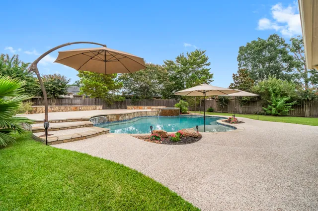 a view of a table and chairs under an umbrella in the garden