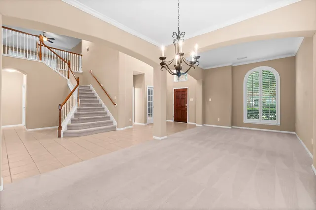 a view of an empty room with a window and a chandelier
