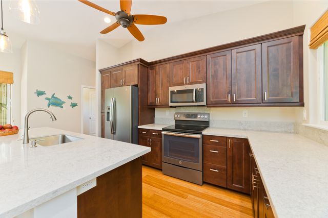 a kitchen with stainless steel appliances granite countertop a sink refrigerator and microwave