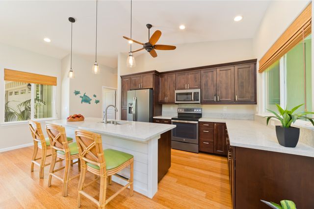 a kitchen with granite countertop a table chairs stainless steel appliances and cabinets