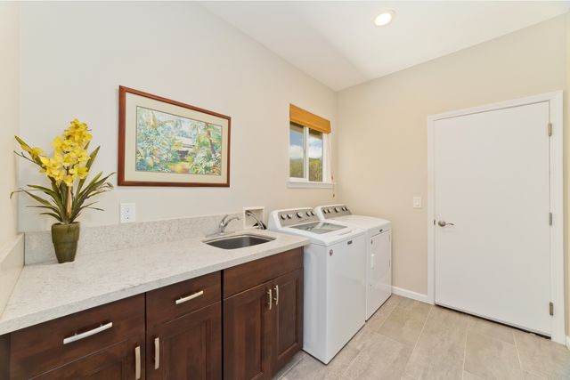 a view of a bathroom with a sink a mirror and a potted plant