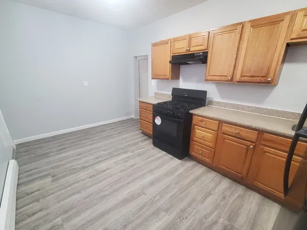 a kitchen with granite countertop wooden cabinets and a stove top oven