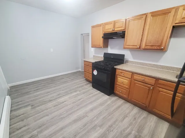 a kitchen with granite countertop wooden cabinets and a stove top oven