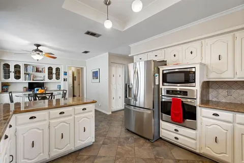 a kitchen with white cabinets and stainless steel appliances
