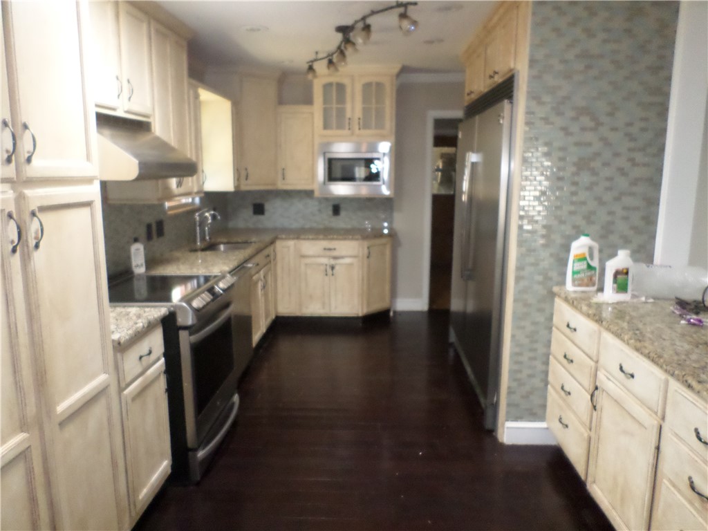 136 Granby Place Portland, TX 78374 - Photo 6 of 16 a kitchen with stainless steel appliances granite countertop a refrigerator a stove and a sink with wooden floor