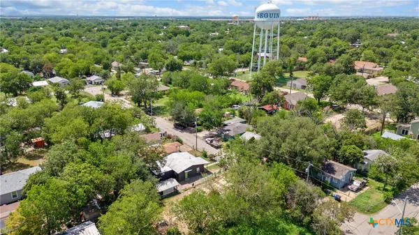 an aerial view of residential houses with outdoor space and trees