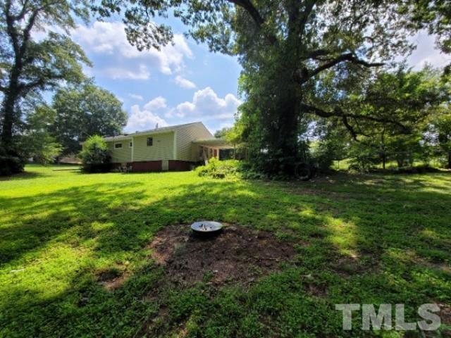 5320 Rock Quarry Road Raleigh, NC 27610 - Photo 11 of 13 a view of backyard with table and chairs and a large tree