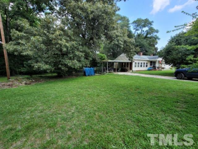 5320 Rock Quarry Road Raleigh, NC 27610 - Photo 3 of 13 a front view of a house with a garden and trees