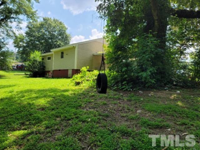 5320 Rock Quarry Road Raleigh, NC 27610 - Photo 7 of 13 a backyard of a house with plants and large tree