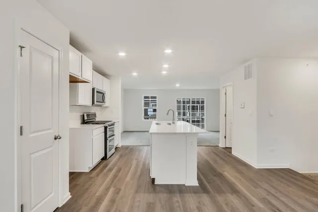 a kitchen with cabinets and wooden floor