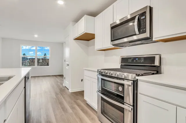 a kitchen with stainless steel appliances granite countertop a stove microwave and oven
