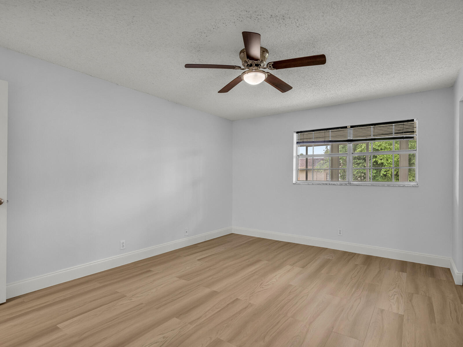 3001 Linton Boulevard, Unit 206C Delray Beach, FL 33445 - Photo 14 of 27 a view of empty room with wooden floor and fan