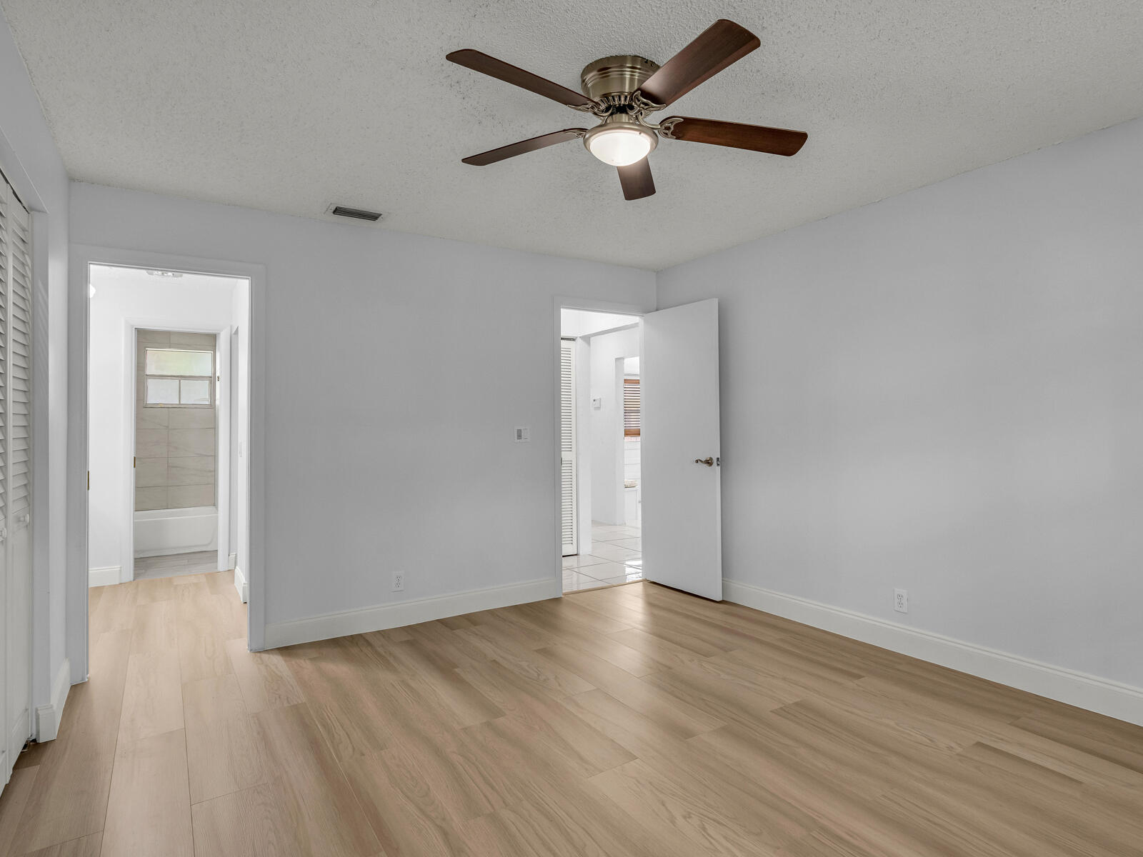 3001 Linton Boulevard, Unit 206C Delray Beach, FL 33445 - Photo 17 of 27 an empty room with wooden floor and a ceiling fan
