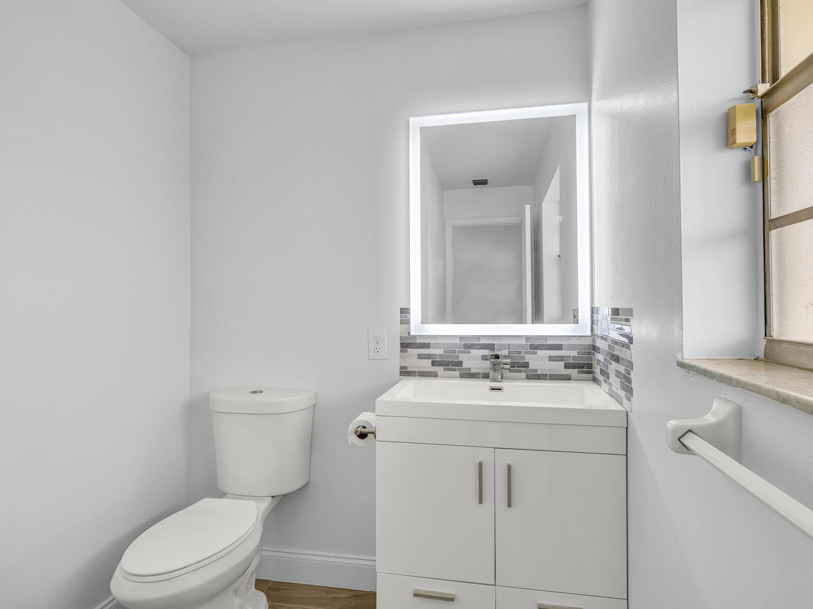 3001 Linton Boulevard, Unit 206C Delray Beach, FL 33445 - Photo 21 of 27 a bathroom with a sink vanity mirror and toilet