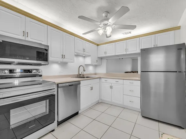 a kitchen with cabinets stainless steel appliances and a sink