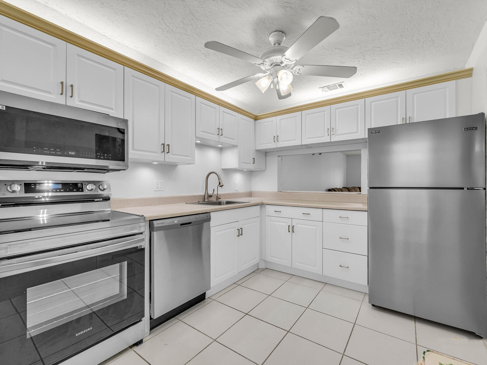 3001 Linton Boulevard, Unit 206C Delray Beach, FL 33445 - Photo 5 of 27 a kitchen with cabinets stainless steel appliances and a sink